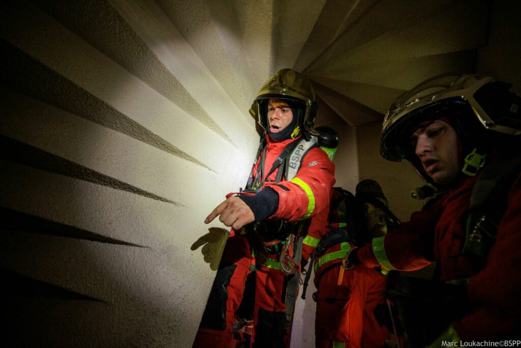 Sapeurs-pompiers de Paris sur intervention pour un feu d'appartement à Paris 16e arrondissement donnant des ordres dans une cage d'escalier