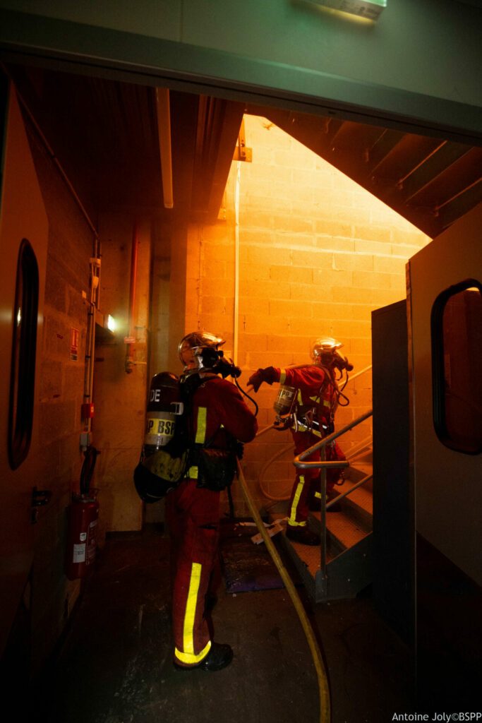 Sapeurs-pompiers de Paris de la BSPP intervenant sur un feu d'entrepôt à Saint-Denis (93) le 1er février 2024, regardant le foyer de l'incendie.