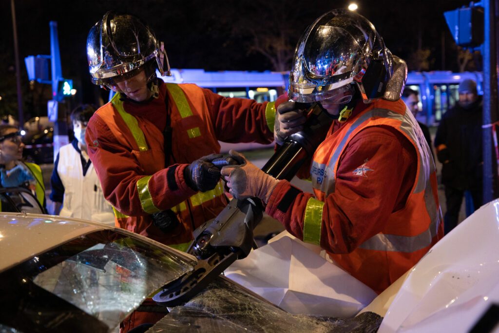 Sapeurs-pompiers de Paris en train de découper le pare-brise d'une voiture 