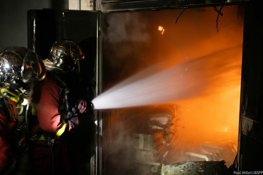 Les sapeurs-pompiers de Paris attaquent le feu d'entrepôt alimentaire avec une lance grande puissance