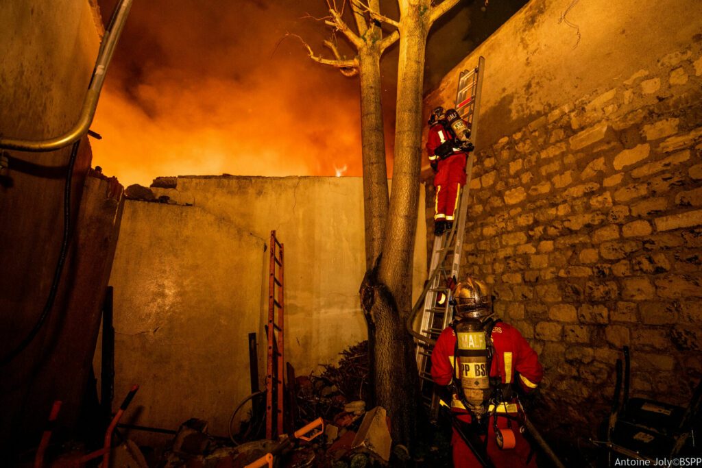 Attaque du feu d'installations précaires par les sapeurs-pompiers de Paris à Ivry-sur-Seine au moyen de la lance du dévidoir tournant sur une échelle à coulisse grand modèle